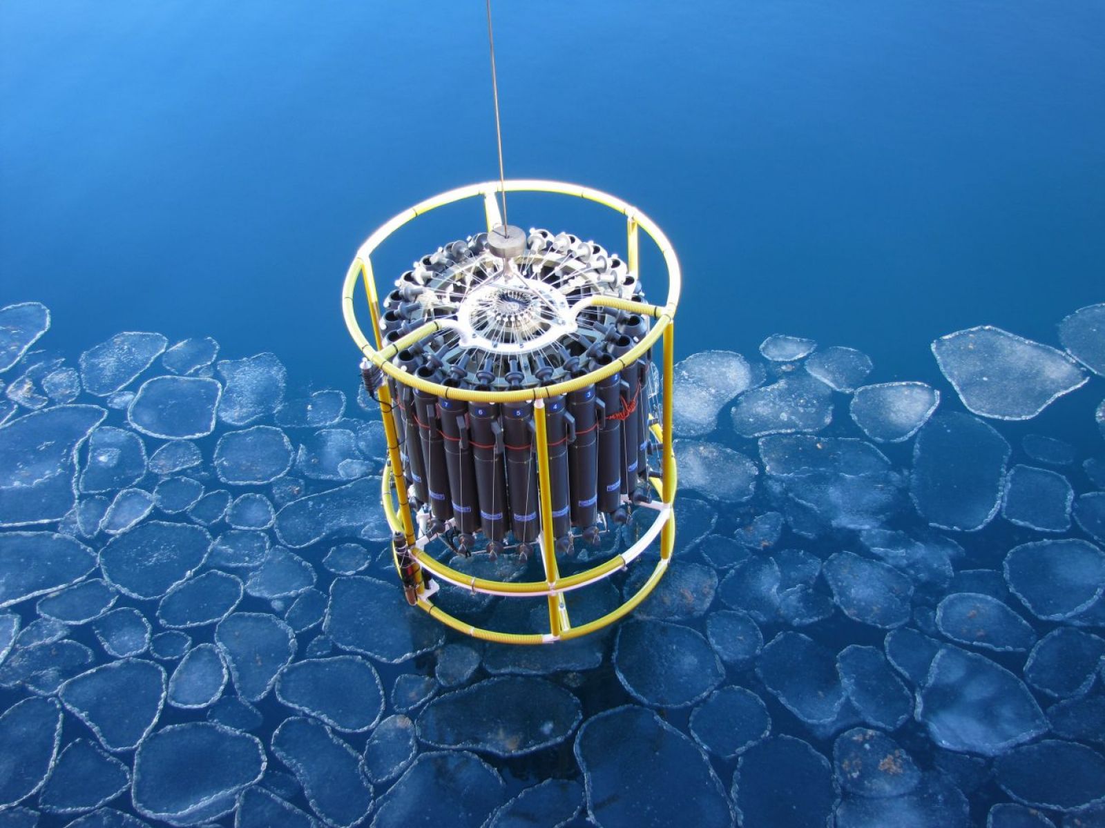 Scientific equipment being lowered into icy water